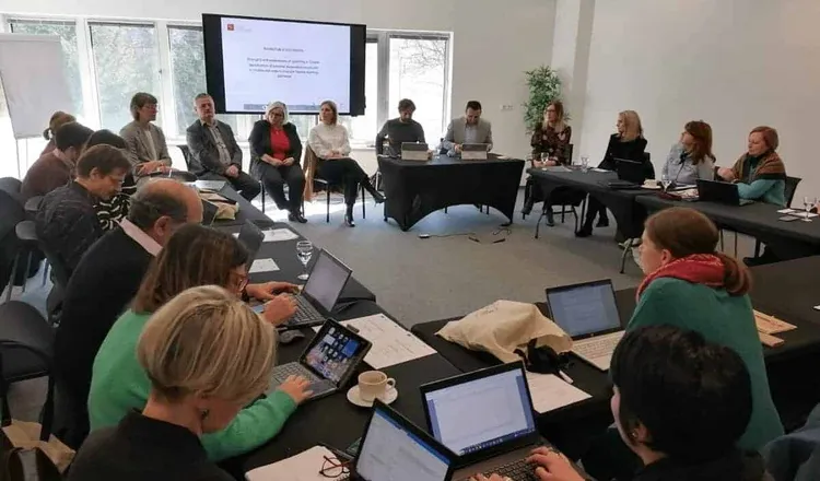 Participants with laptops around tables at the PartnerUp kick-off meeting in Croatia, a presentation on a screen behind.