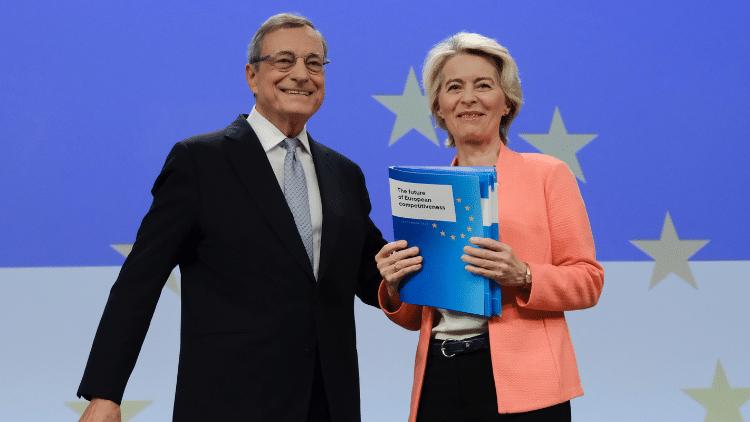 Smiling man and woman presenting report against backdrop of EU stars